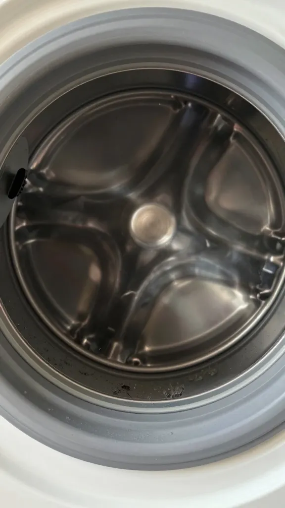 closeup of grimy top-loader washer rim with gray gunk