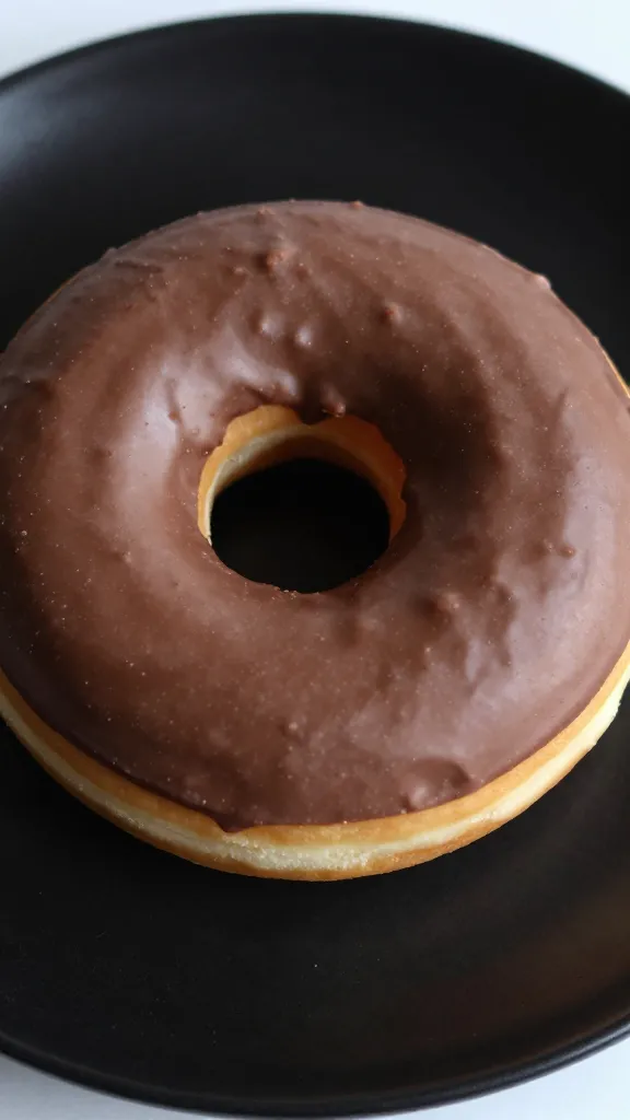 closeup single keto chocolate donut on matte black plate